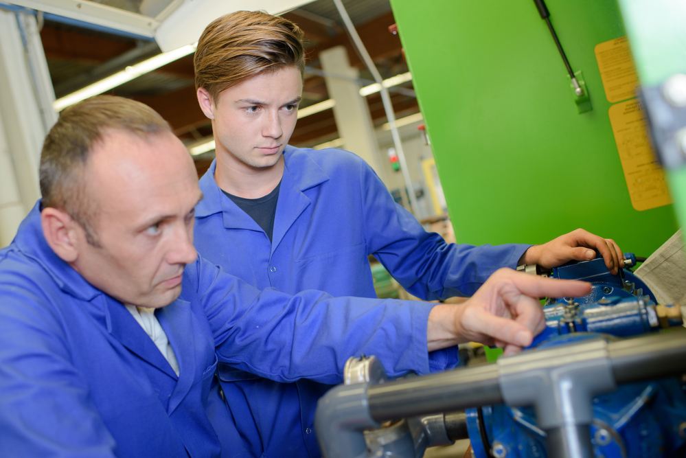 Engineers examining machine and engineer